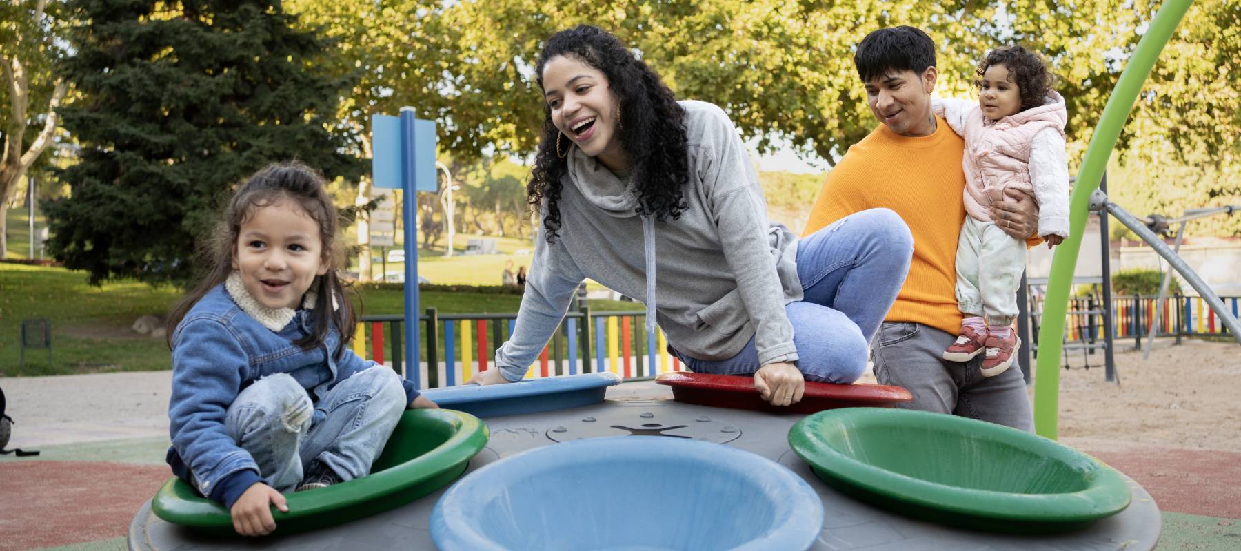 Children are laughing and enjoying themselves with their parents in a playground