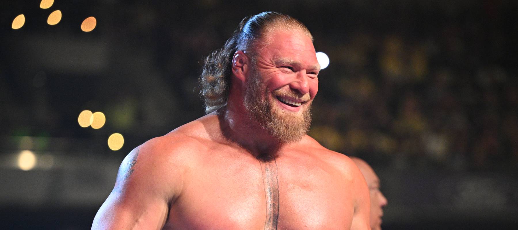 Brock Lesnar smiles broadly in the ring.
