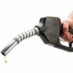 Money sticking out of automobile fuel tank opening signifying and illustrating the high cost of gas.