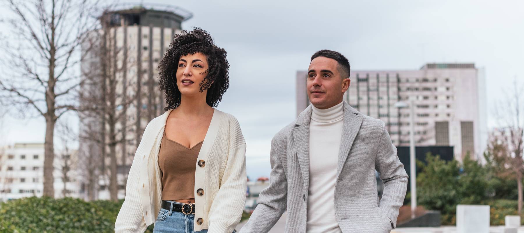 a young interracial couple walking outside holding hands