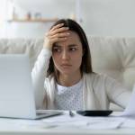 Confused young woman calculating household expenses, have problems paying bills online