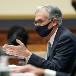 Fed Chairman Jerome Powell wearing mask speaks into microphone