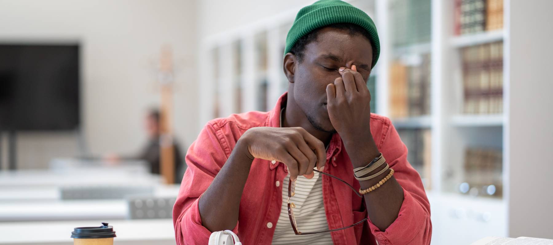 tired Black male college student exhausted sit on campus