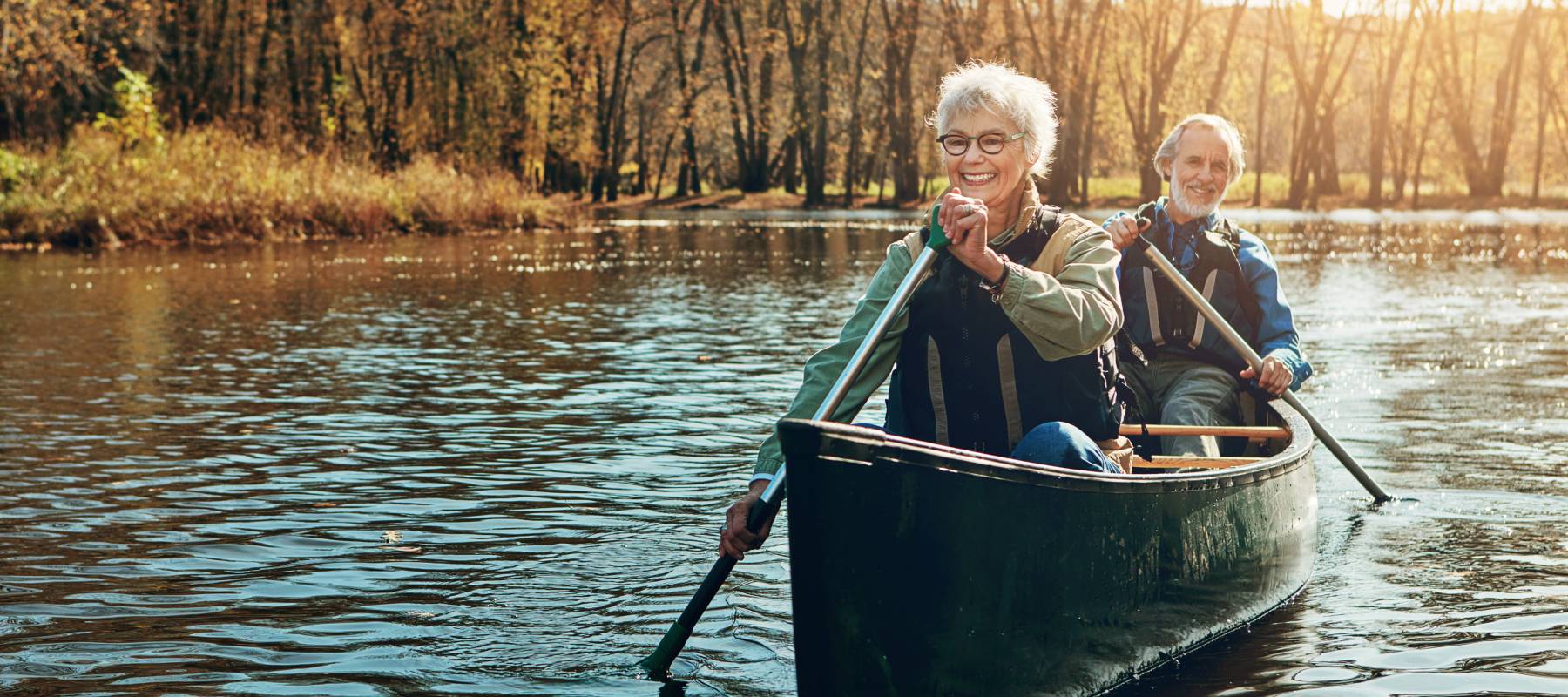 Caucasian senior couple canoeing in the autumn/early winter