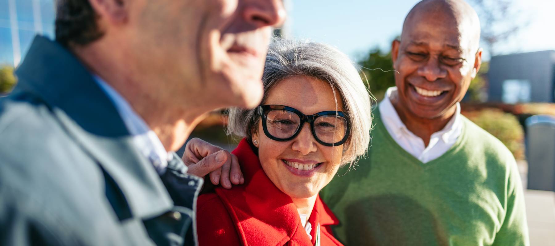 a group of three diverse seniors outside, enjoying the sun