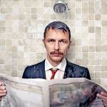 Man reads newspaper in the shower, soaking wet