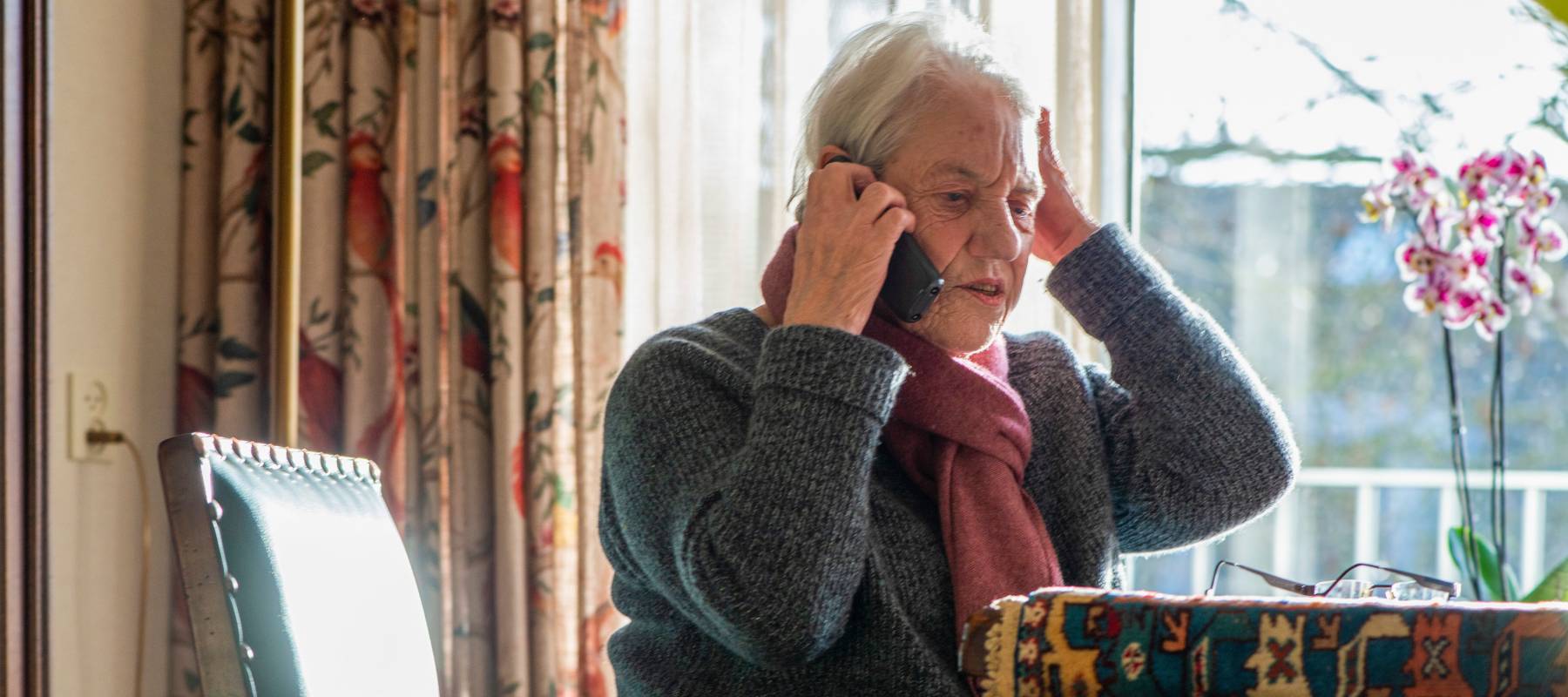 Older woman picks up scam phone call.