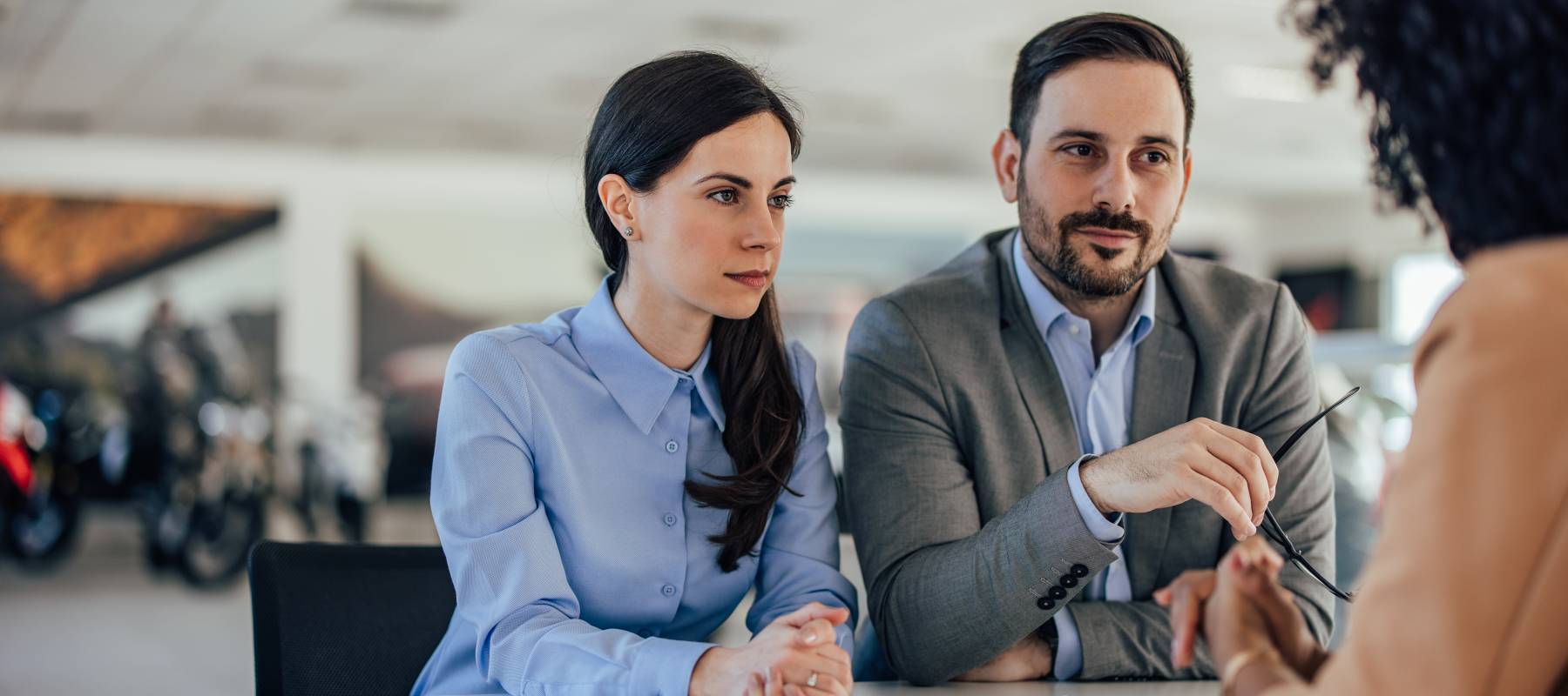 Man and woman negotiate rate at car dealership