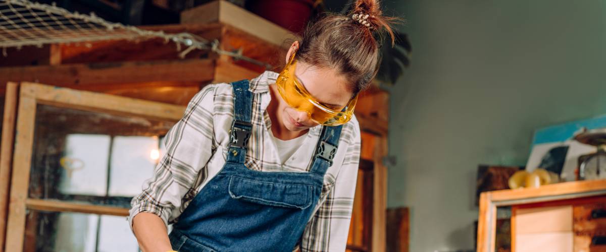 woman running a lathe at a carpentry bench