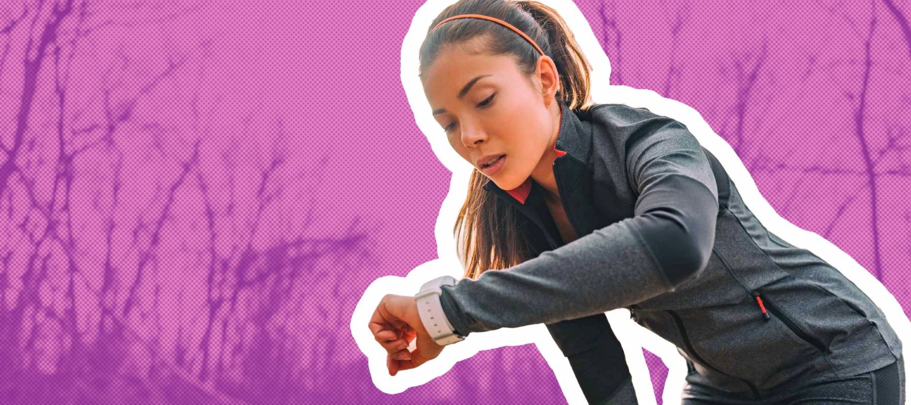 woman running on a trail, looking at smart watch, bent over