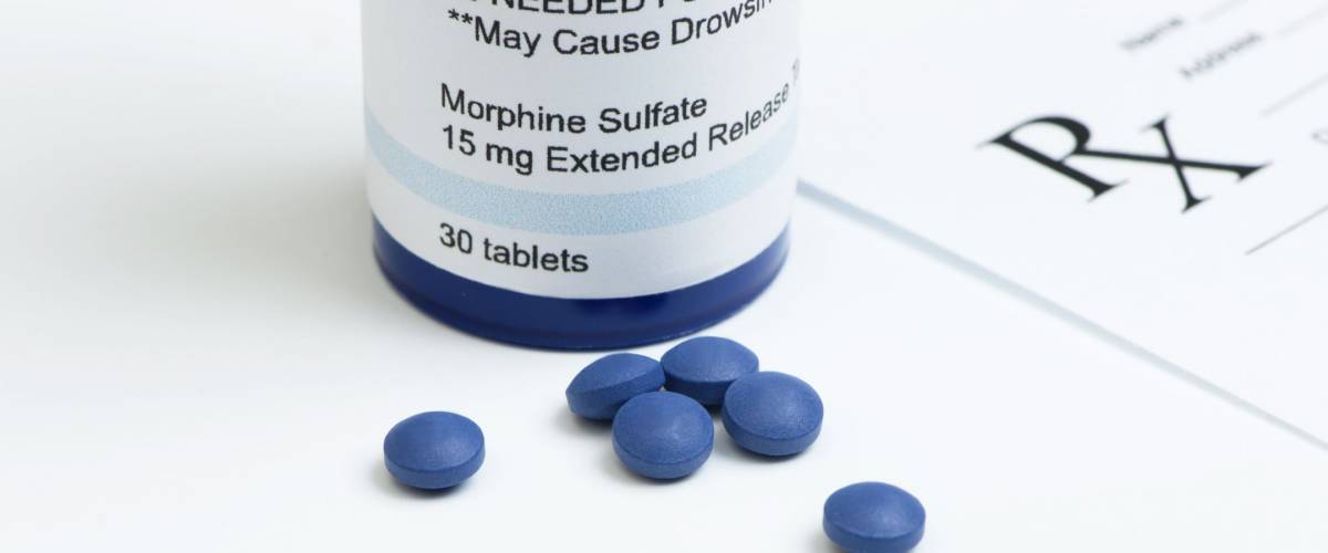 Morphine sulfate pills with bottle and prescription.
