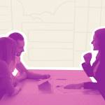 Side view of woman in suit speaking with man and woman across a table in an office