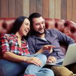 young couple looking at laptop and laughing