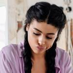 A pensive young woman reviews plans while renovating a home.