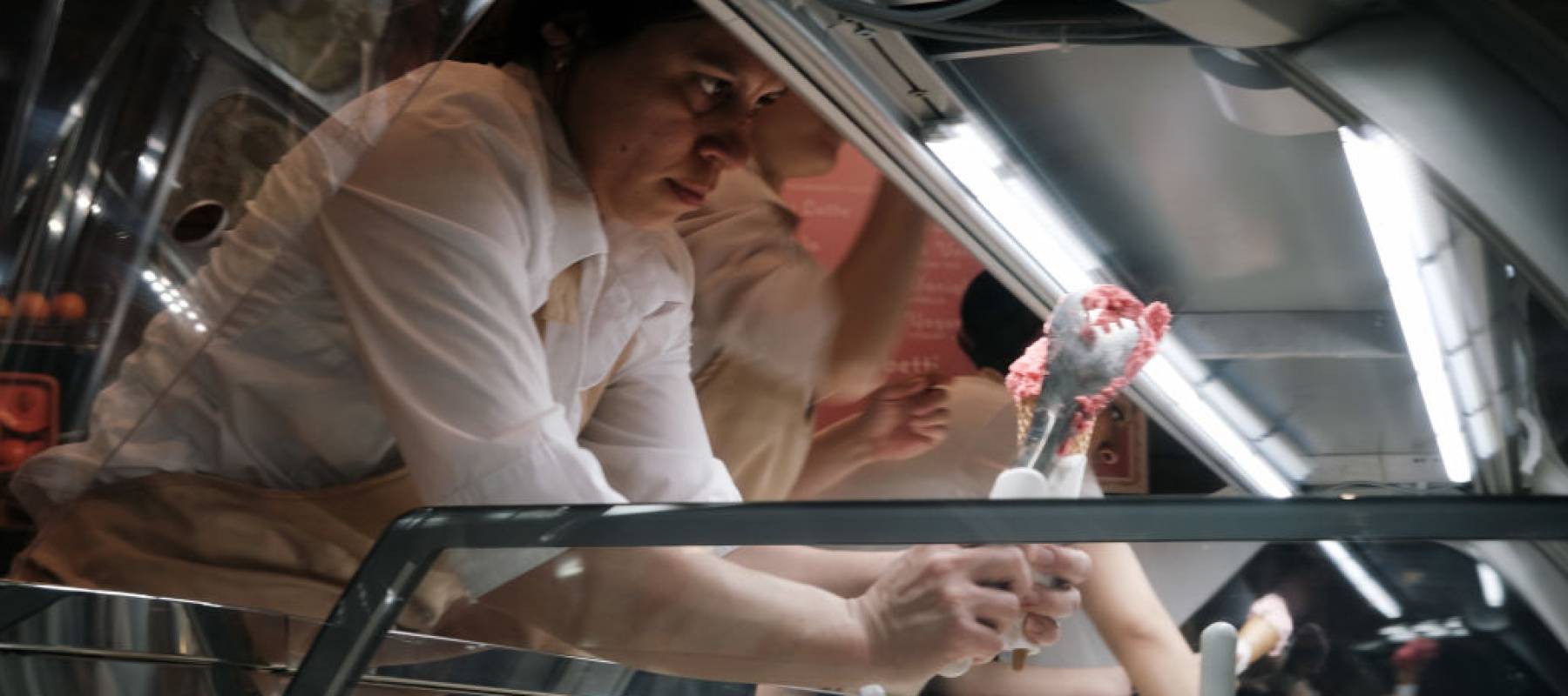 A woman preparing an ice cream cone.