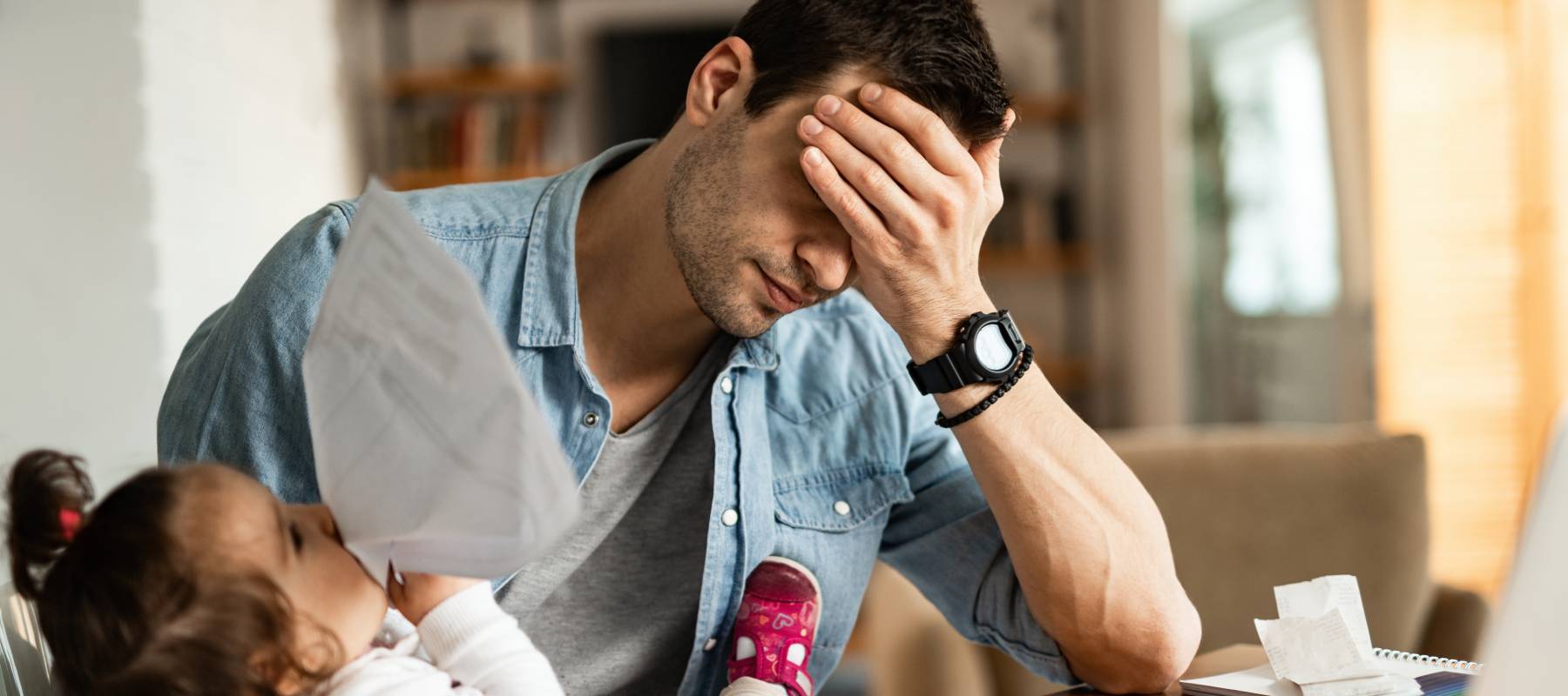 A dad at home taking care of his child.