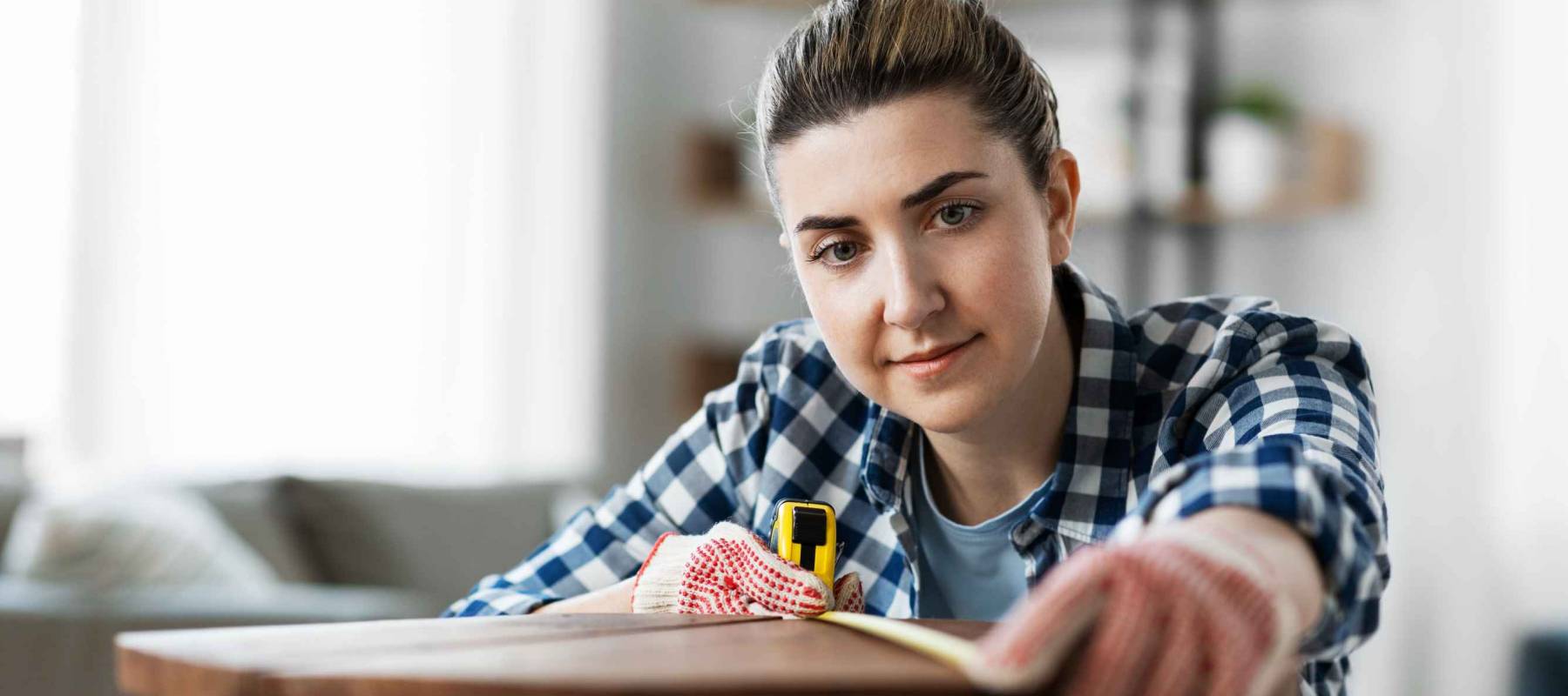 repair, diy and home improvement concept - woman with ruler measuring old wooden table for renovation