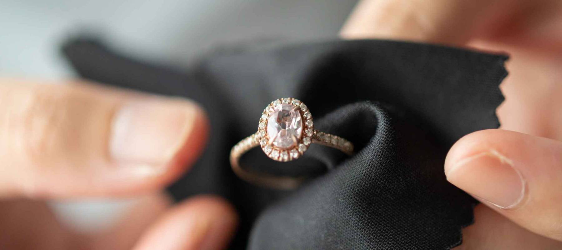 Jeweller cleaning jewelry diamond ring with fabric cloth