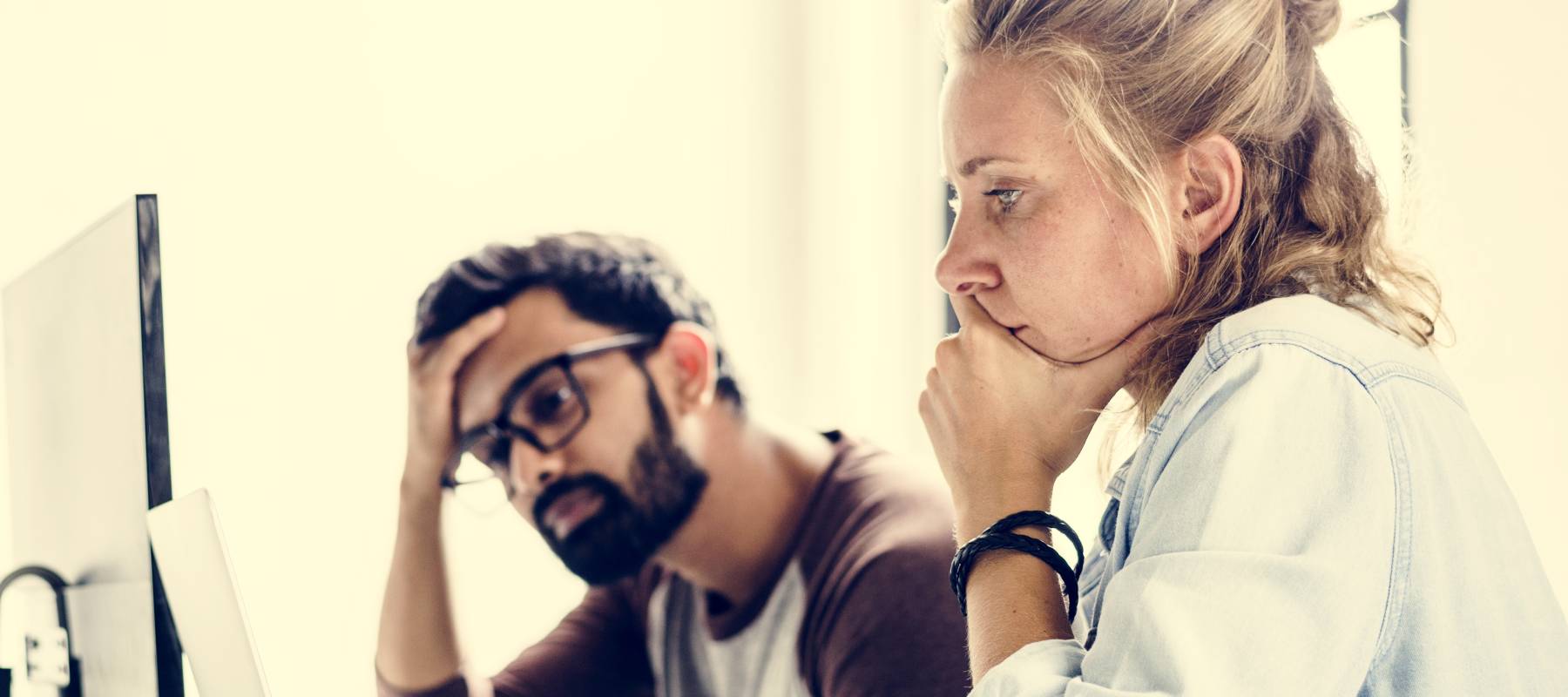 Stressed couple looks at financial information on the computer.