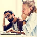Stressed couple looks at financial information on the computer.