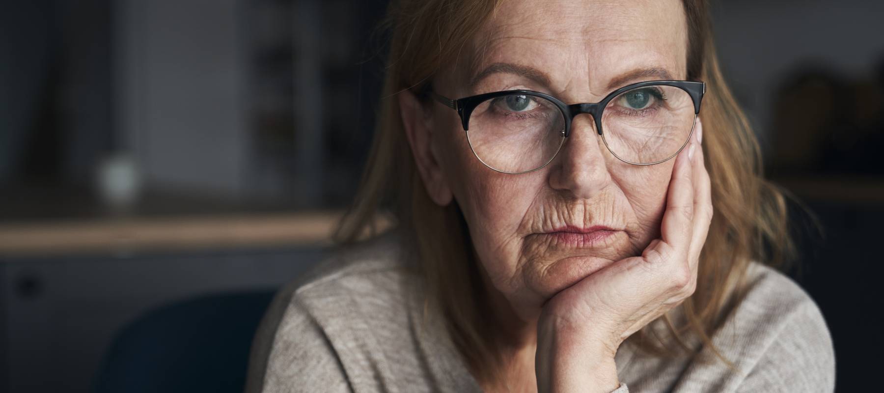 An experienced woman looks off into the distance.