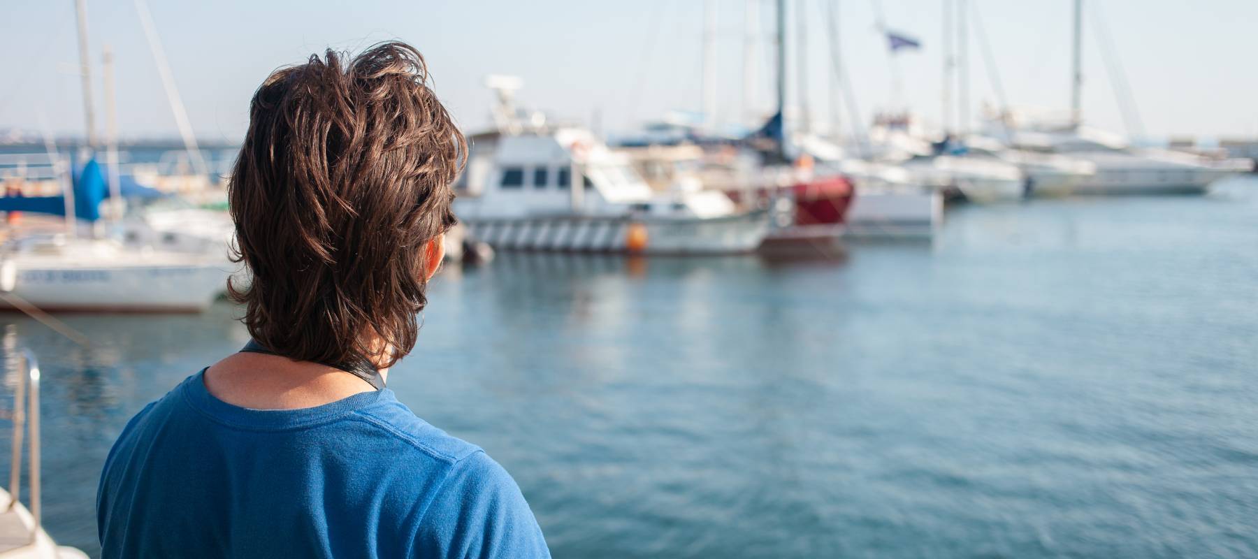 Woman admiring boats at a marina.