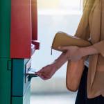 Closeup woman holding the wallet and withdrawing the cash via ATM