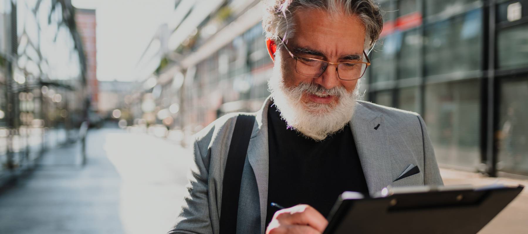 A man standing outside taking notes.