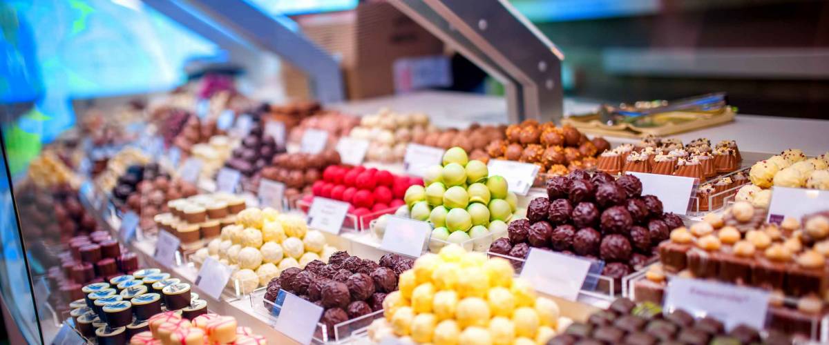 chocolate truffles, candies and sweets store on showcase in factory store. Chocolate bit sized for sale in local chocolate store