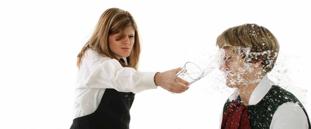 Angry waitress throwing drink in customer's face.