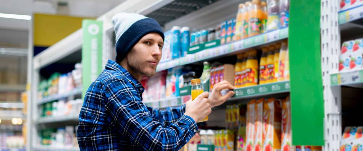 the kleptomania concept, a man in the grocery store stealing food and put it in the pocket