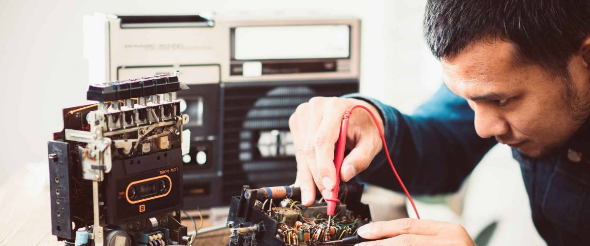 Technician repairing an old radio cassette recorder.
