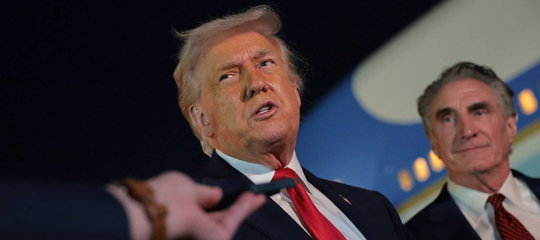 U.S. President Donald Trump (L) talks with reporters as U.S. Secretary of the Interior Doug Burgum (R) looks on