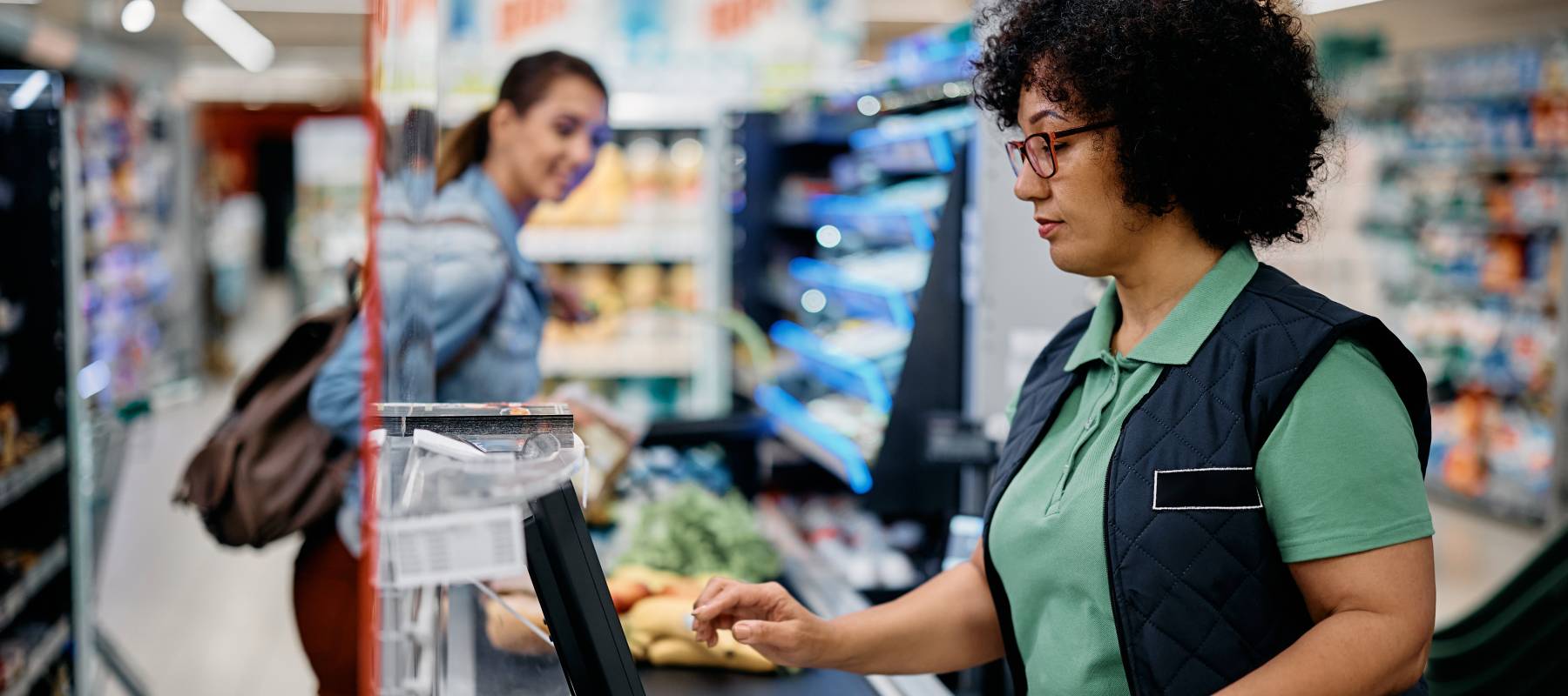 A grocery store cashier rings up a customer's items.