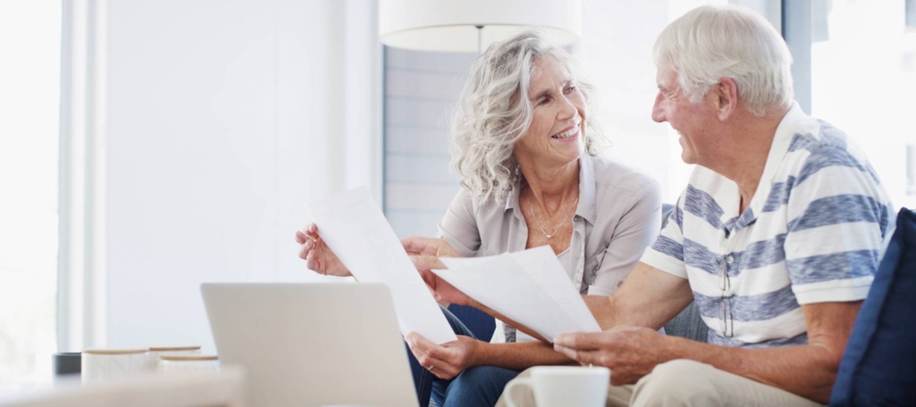 Senior, happy couple with documents and laptop for financial planning.