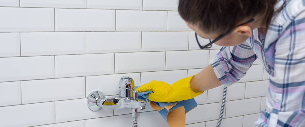 Woman is cleaning in the bathroom at home
