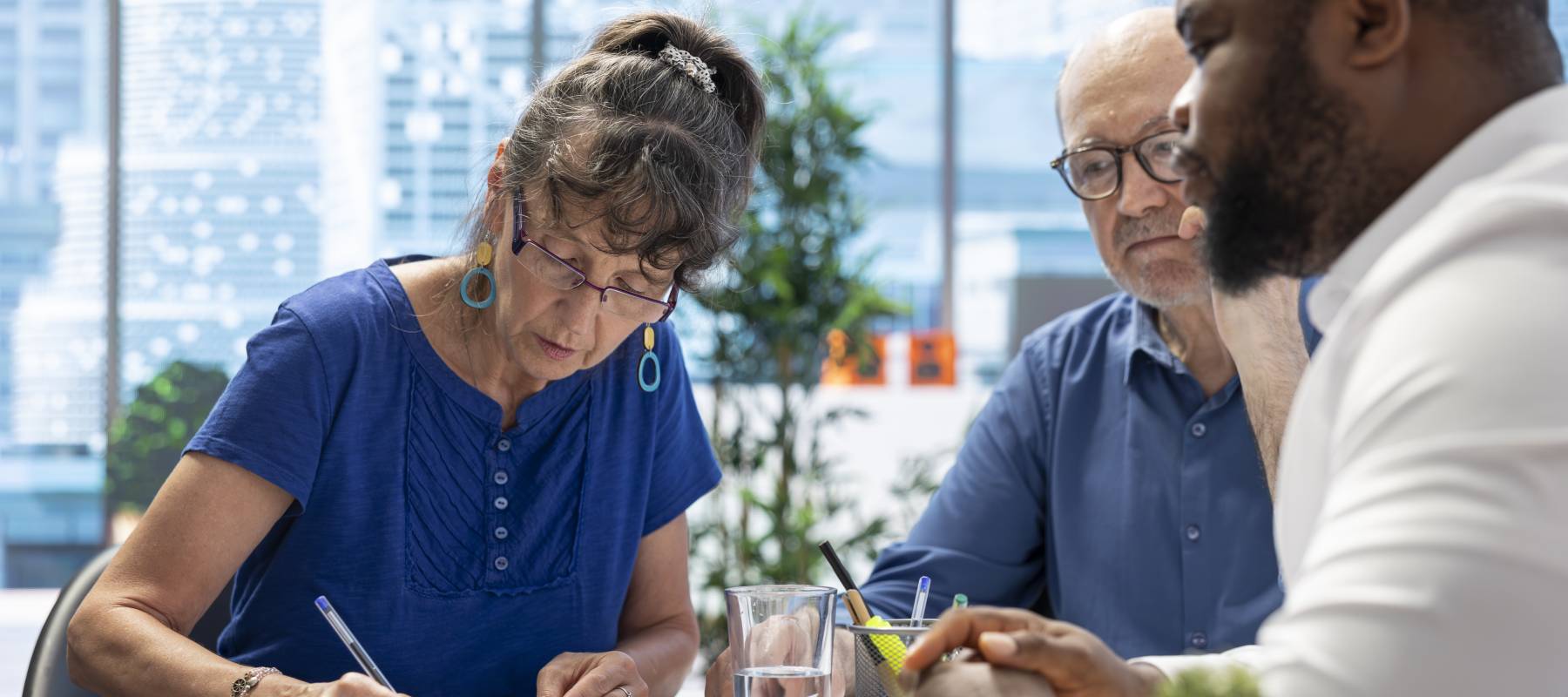 A woman signs a financial document.