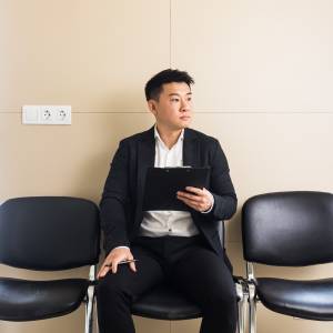 A man waiting for a job interview, with Americans face an uncertain job market.