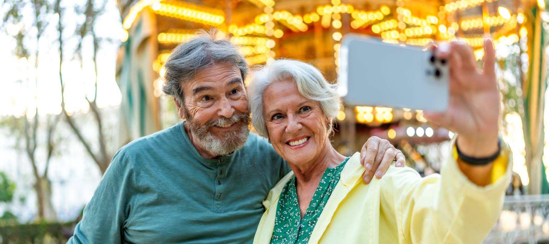 Senior couple talking selfie in a city fair.