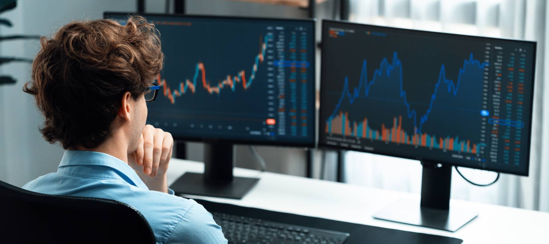 A man watches the stock market on his computer.