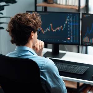 A man watches the stock market on his computer.