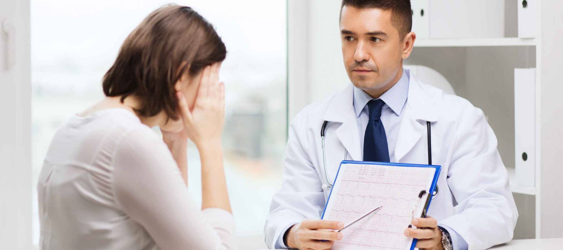 medicine, health care and people concept - doctor with clipboard and young woman meeting at hospital