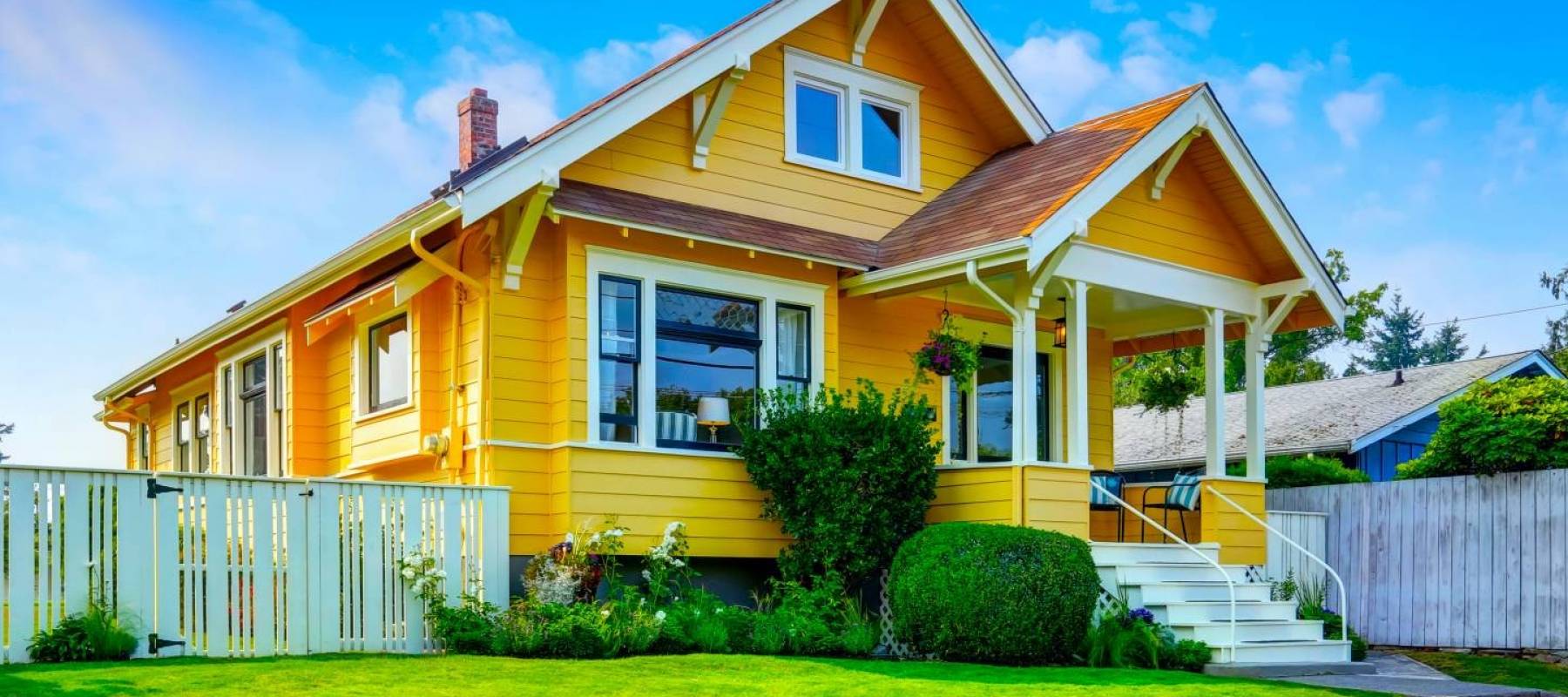 American craftsman home with yellow exterior paint and well kept front garden. Northwest, USA