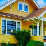 American craftsman home with yellow exterior paint and well kept front garden. Northwest, USA