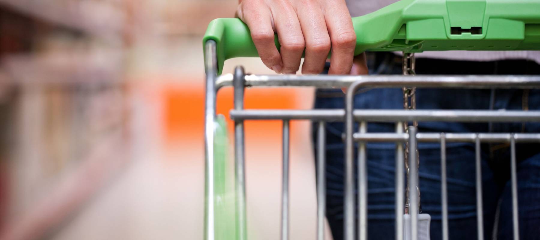 Closeup of female shopper with trolley at supermarket