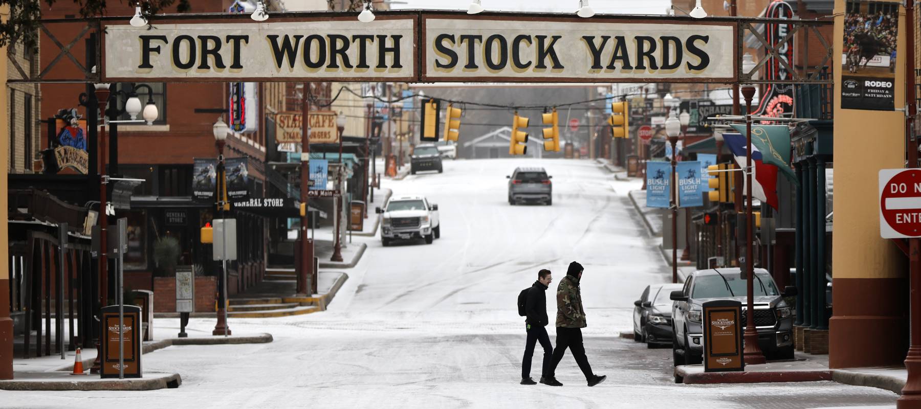 People cross an icy street in Fort Worth, Texas, in the northern part of the state that experienced a surge of burst pipes and water main breaks after a thaw.