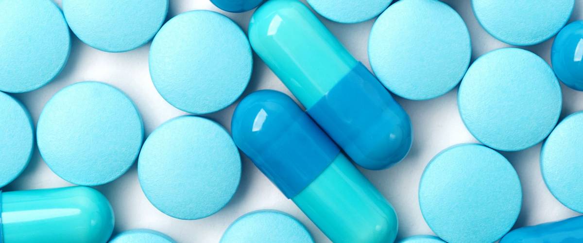 Medical background with blue pills and blue capsules