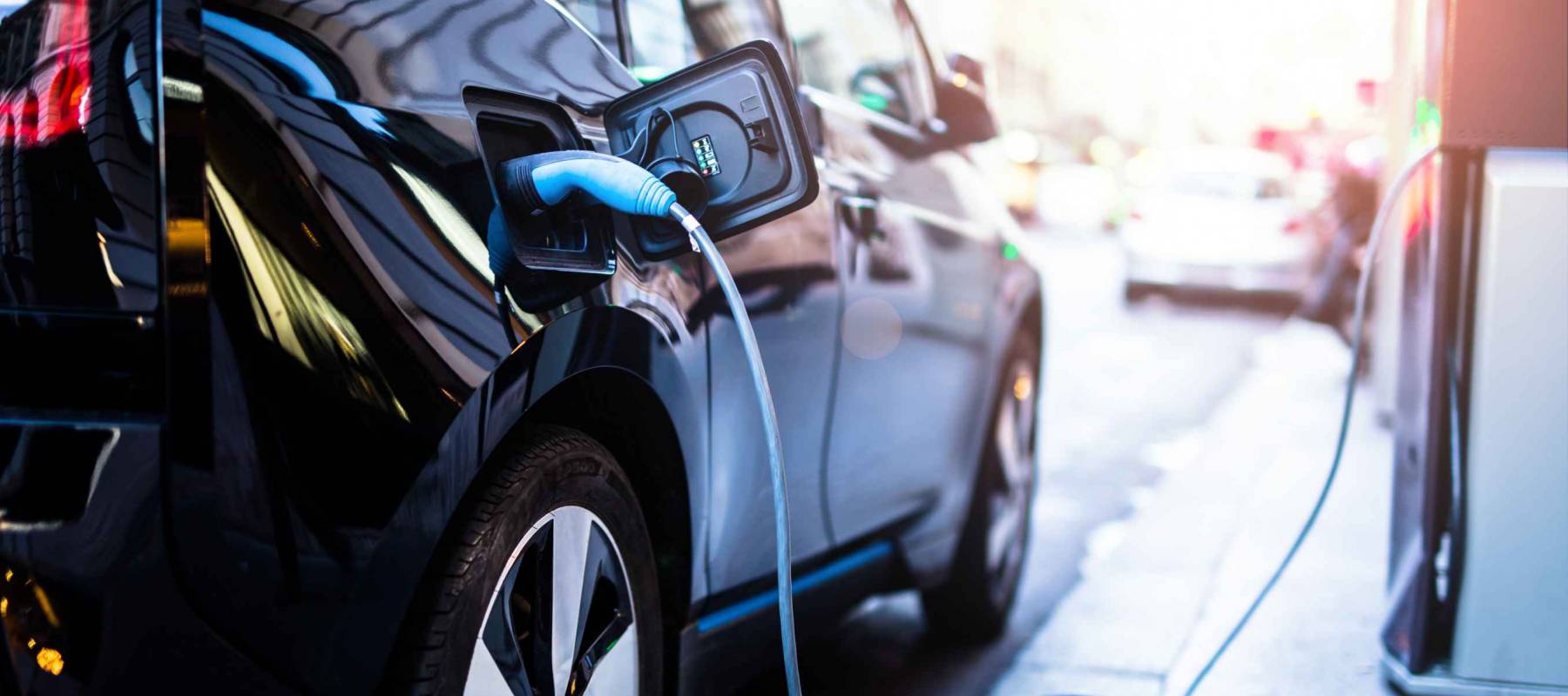 Charging modern electric car on the street.
