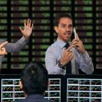 Trader gesturing at stock exchange