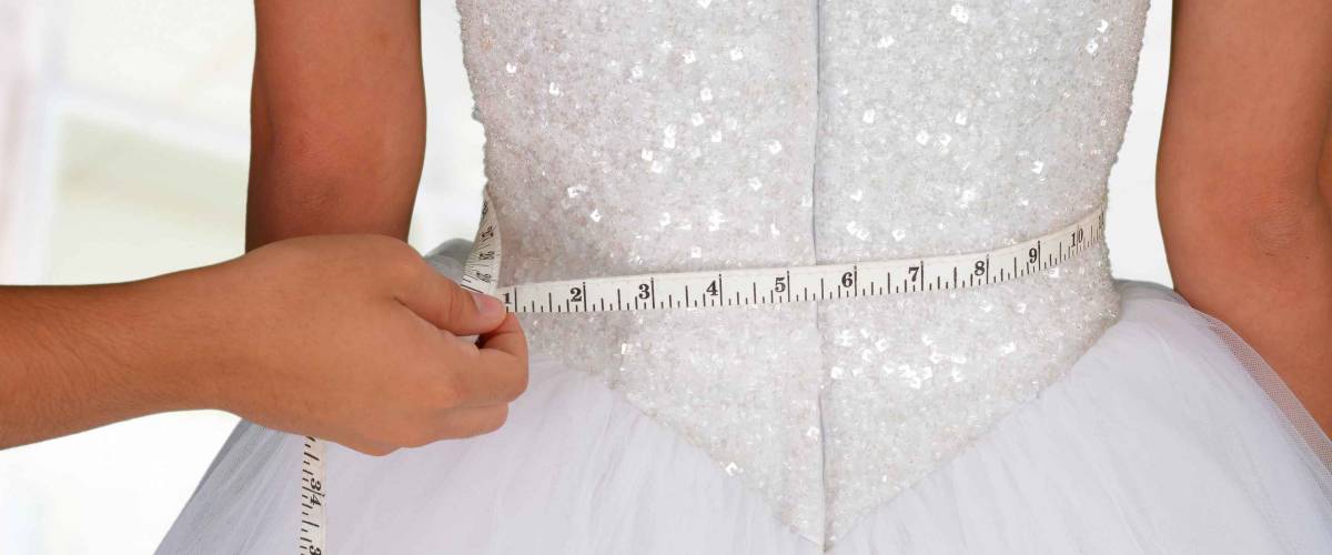 Woman in a wedding dress getting measured